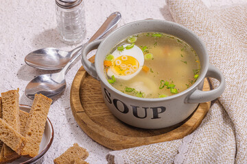 Meatball soup with boiled egg, ditalini pasta, vegetables and fresh herbs. Healthy chicken broth