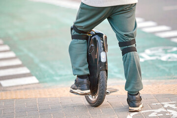Man in protective gear on electric mono wheel waiting on crosswalk. Man on electric single wheel on crosswalk, rear view. Mobile portable individual transportation vehicle (EUC) © Tricky Shark