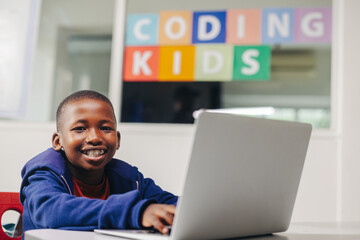 Young black student learning to code in a computer-based learning school