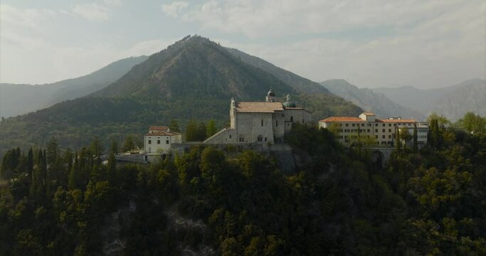 Montecastello shrine with mountain in background, Tignale on Lake Garda in Lombardy, Italy. Aerial sideways