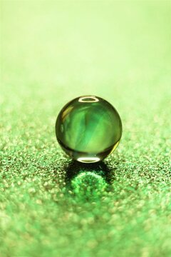 One glass balls on shiny green table