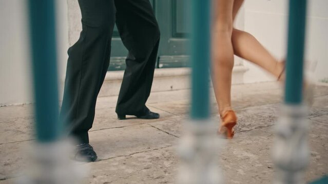 Legs latino couple dancing on street pavement close up. Dancers practicing steps