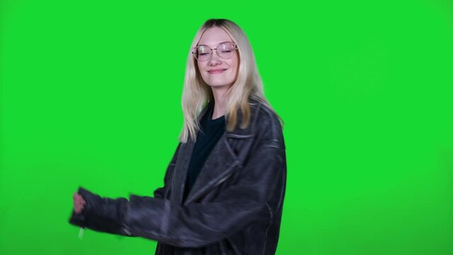 beautiful young girl in a leather rock jacket with long hair actively dances and turns her head on a green background, chromakey