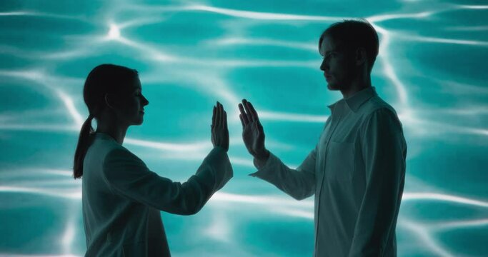 Beauty Footage in a Mystical Water World: Young Female and Male Performing with Confidence, Looking at Each Other and Gesturing with Hands, Standing in Front of an Abstract Digital Animation