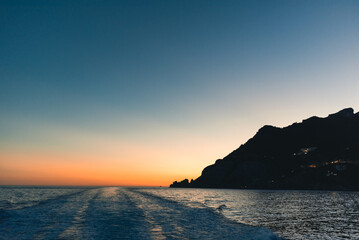 Naklejka na ściany i meble Motorboat wake at sunset light