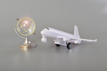 Airplane and crystal globe on grey background. Travel concept. Booking service or travel agency...