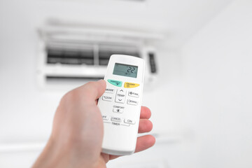 Man holding a modern AC unit remote.