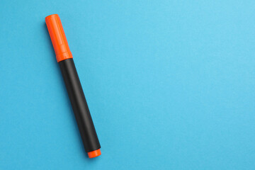 Bright orange marker on light blue background, top view. Space for text