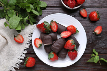 Delicious glazed curd snacks, mint leaves and fresh strawberries on wooden table, flat lay