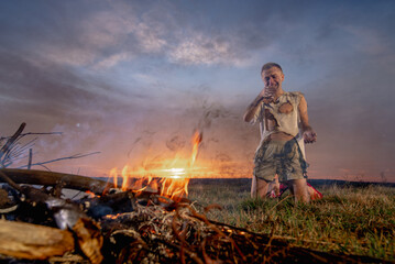 a civilian man in despair near burnt property, in burnt clothes, around a field, war