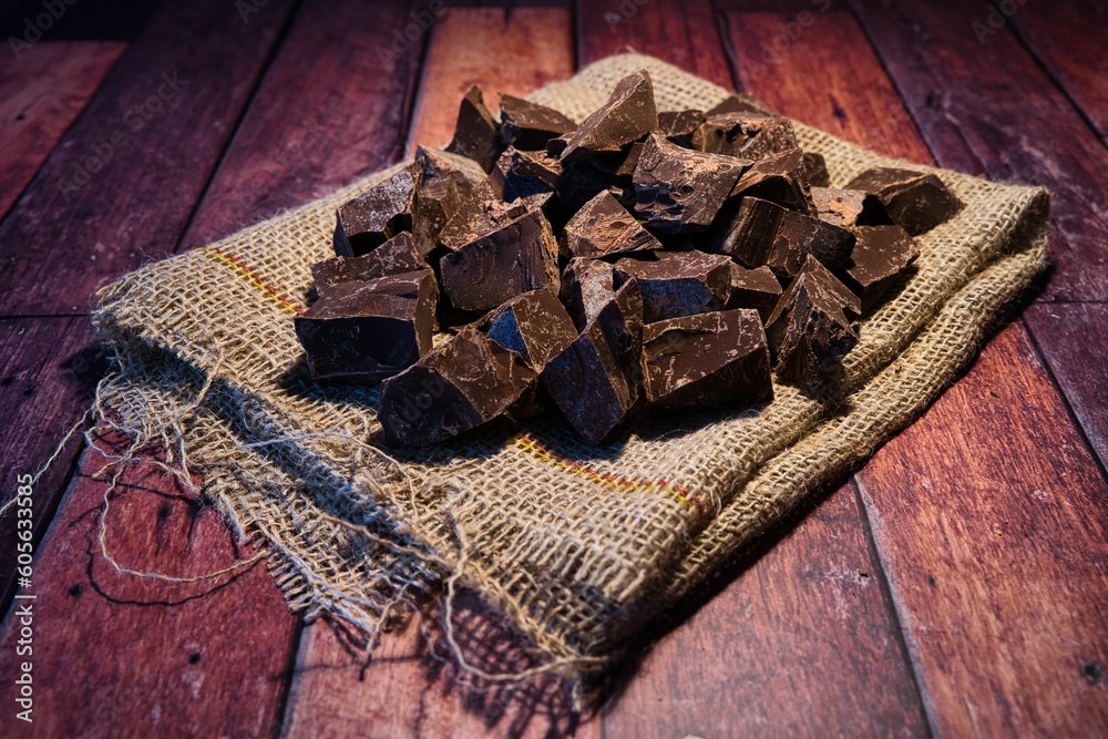 Poster Closeup of chocolate on a sack on a wooden surface