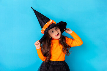 Halloween Party girl. Funny child girl in witch costume on Halloween on blue background