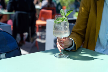 Woman holding glass of Spritz aperitif drink cocktail. Summer refreshing drink concept