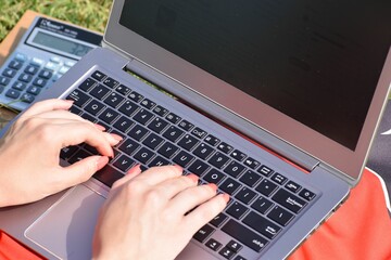 Fototapeta na wymiar Closeup of a woman's hands using laptop