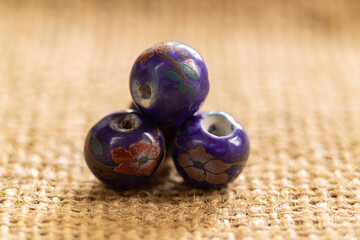 Bright blueberry-colored beads on a burlap background
