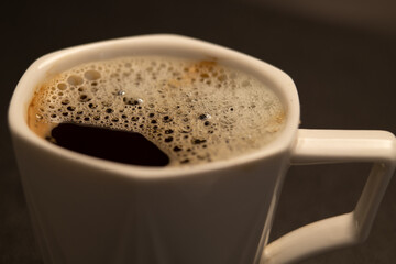 A cup of fresh hot coffee with foam on the surface