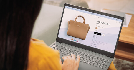 Over-the-Shoulder: Woman Using Laptop to Buy a Bag: Female Browsing through Internet, Doing Online Shopping, Comparing Prices for Items on Sale on a Retail Brand Website. E-commerce Concept