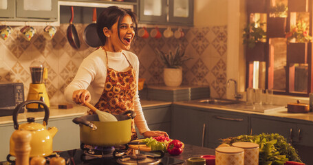 Indian Girl Preparing Food: Magnificent Young Woman Smiling Happily as She Gets Surprised by Family and Friends Visting While Preparing Delicious Home-Cooked Traditional Meal in Cosy Kitchen