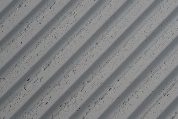 grey concrete wall with deep textured 3d lines vertical, diagonal or horizontal with a lot of copy space for text background