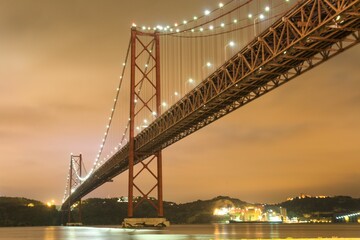 Fototapeta premium Low angle shot of illuminated bridge over river against the sky