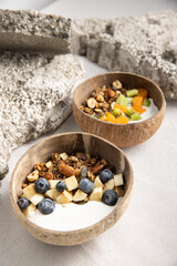 Vertical and top shot of the muesli with yogurt and fruits in a bowl