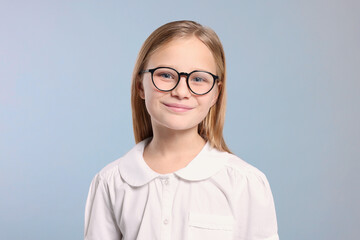 Portrait of cute girl in glasses on light grey background
