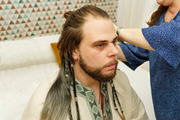 young man with Viking-style hairstyle prepares to party