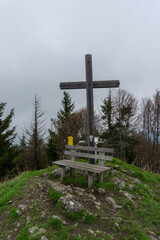 cross on the top of mountain with a bench in Salzburg, Austria, on a day in spring