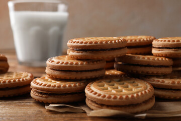 Tasty sandwich cookies with cream on wooden table, closeup
