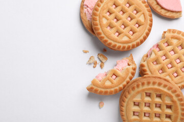 Tasty sandwich cookies with cream on white background, flat lay. Space for text