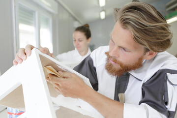 Obraz premium sanding and smoothing wood with black sandpaper