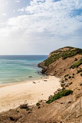 Fototapeta na wymiar Vertical shot of a sunny rocky seashore on a summer day in Kef Abbed, Tunisia