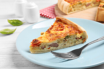 Delicious homemade vegetable quiche and fork on white wooden table, closeup