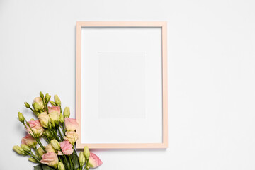 Fototapeta na wymiar Empty photo frame and beautiful flowers on white background, top view. Space for design