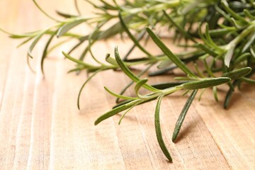 Sprigs of fresh rosemary on wooden table, closeup. Space for text