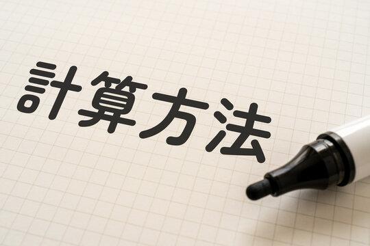計算方法と書かれたノートとマーカー