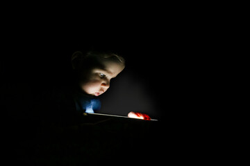 Baby spielt mit Licht im Dunkeln