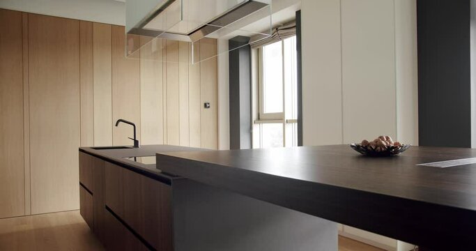 Modern interior in luxury house. Interior of a minimalist kitchen. Light Wood Wall and Floors. Modern Kitchen room with minimalist dining table. Domestic Kitchen with modern sink.