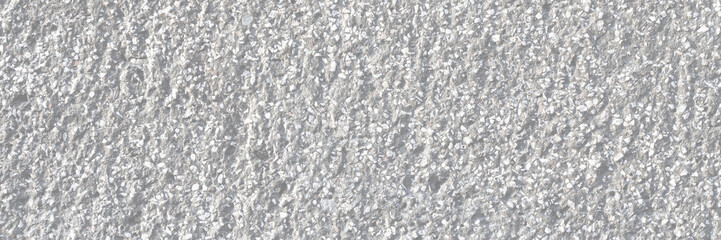 Texture of a decorative concrete wall. Rough gray surface with a grainy pattern of small stones and dents. Wide panoramic texture for background and design.