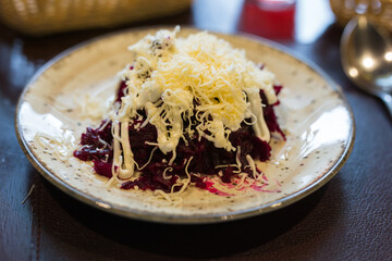 mix of beets, cheese, mayonnaise on a plate in restaurant