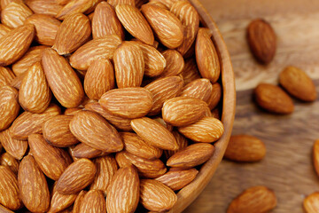 Organic almond nut raw peeled in bowl on wooden table, top view. Healthy snack or for vegetarians. copy space banner.