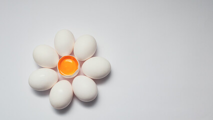 Flower shaped raw egg. Few white eggs, whole and broken egg half with a yolk isolated on a white background