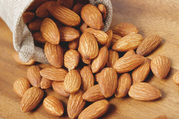 Almonds in a sack on wooden background