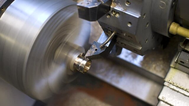 An automated lathe turns a brass product in automatic mode. Production industrial video