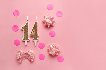 Number 14 on pastel pink background with festive decor. Happy birthday candles. The concept of celebrating a birthday, anniversary, important date, holiday. Copy space. Banner