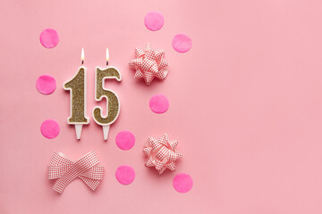 Number 15 on pastel pink background with festive decor. Happy birthday candles. The concept of celebrating a birthday, anniversary, important date, holiday. Copy space. Banner