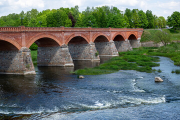 Fototapeta premium Public bridge over river Venta in Kuldiga in May in Latvia