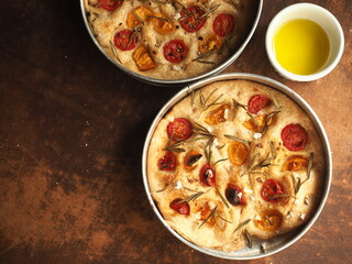 Focaccia with rosemary and tomato in round pan