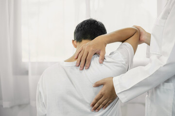 Obraz premium Female physiotherapists provide assistance to male patients with elbow injuries and examine patients in rehabilitation centers. Physiotherapy concepts