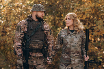 A married couple of the US military with weapons in their hands. Close up.